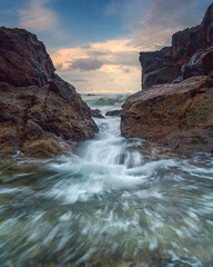 The waves gently lap against the shore, creating a soothing melody that complements the vibrant colors of the sky