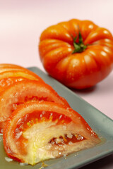 Fresh, juicy tomato slices seasoned with olive oil and salt, served on a plate with a whole tomato, ready to be enjoyed