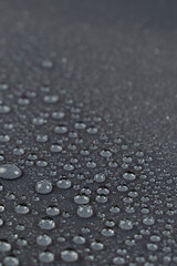 Water drops on the dark gray fabric, vertical