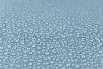 Water drops on the light blue fabric, horizontal