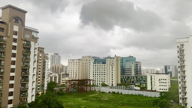 4K timelapse of fast-moving clouds sweeping over Gurgaon city skyline. Urban buildings stand against the dynamic sky, creating a dramatic contrast between architecture and natural atmospheric movement