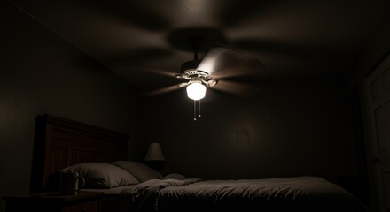 Dimly lit bedroom with ceiling fan and single light, minimalistic scene with shadowed bed, night ambiance, quiet and contemplative atmosphere in a cozy, dark environment
