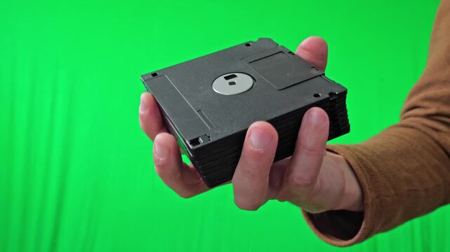 A nostalgic and technical mood is captured as a hand holds a fanned stack of classic 3.5-inch floppy disks, ready for integration into various digital or historical themes