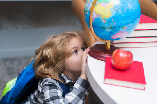 Explorer and discovery. Pupil looking at globe in library at the elementary school. Back to school. Portrait of cute child school boy. Clever kid with school supplies.
