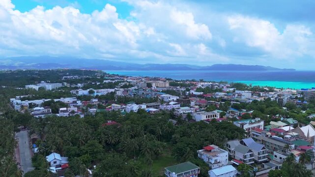 4K drone footage of Boracay&rsquo;s urban center with lush trees, mountains, and crystal-clear coastline&mdash;ideal for real estate, travel, or cityscape content.