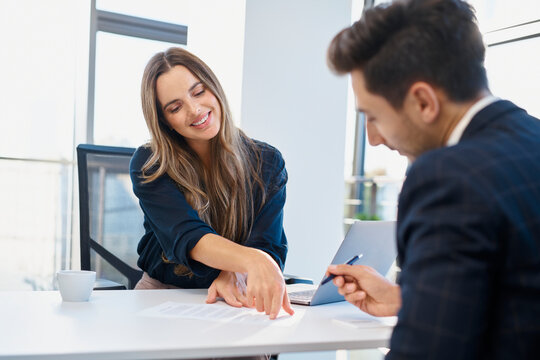 Recruiter assisting candidate filling form at desk in office