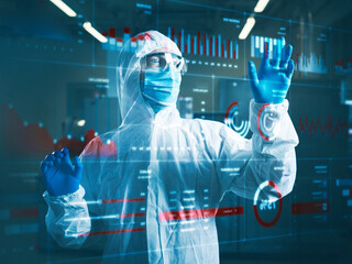Industrial worker wearing protective workwear using transparent touch screen in clean room