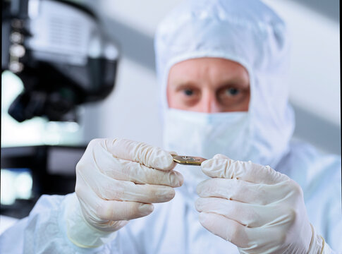Engineer scrutinizing computer chip in laboratory