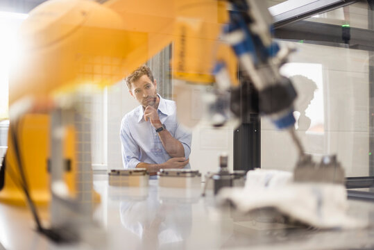 Businessman checking industrial robot in high tech company
