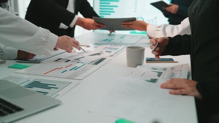 A dynamic group of business professionals engages in an interactive meeting, analyzing various data charts and collaborating to strategize for future success. SACTR - Powered by Adobe