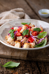 Fresh Italian Panzanella Salad with Tomatoes, Bread and Basil on Rustic Wooden Table