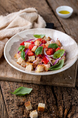 Fresh Italian Panzanella Salad with Tomatoes, Bread and Basil on Rustic Wooden Table