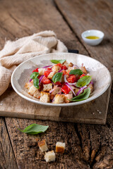 Fresh Italian Panzanella Salad with Tomatoes, Bread and Basil on Rustic Wooden Table