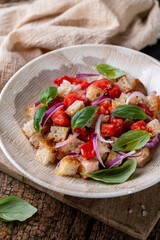 Fresh Italian Panzanella Salad with Tomatoes, Bread and Basil on Rustic Wooden Table