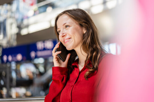 Smiling woman with brown hair talking on mobile phone