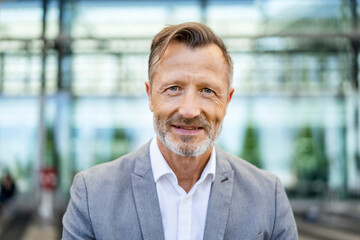 Smiling mature businessman in gray blazer