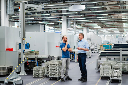 Employee and businessman talking in a factory