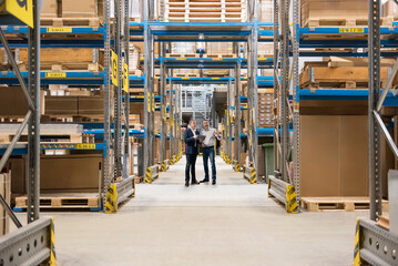 Businessmen standing and planning in warehouse