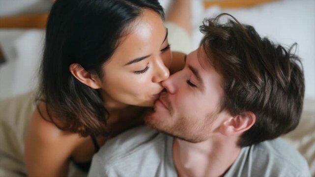 A beautiful woman with dark hair and tanned skin, smiling at her boyfriend in bed
