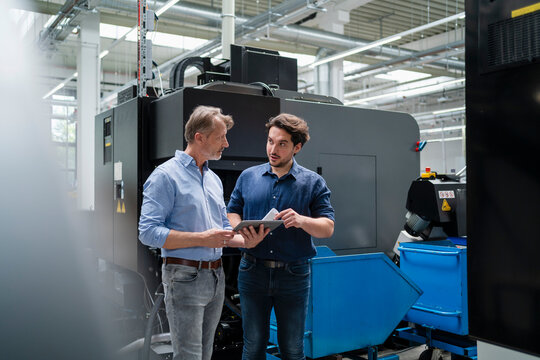 Business colleagues planning strategies standing on production floor in factory