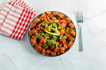 Soya Manchurian is a flavorful Indo-Chinese dish made with soya chunks tossed in spicy, tangy sauce, garnished with spring onions and bell peppers.
