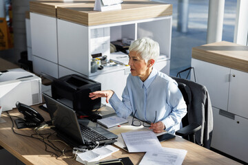 Businesswoman gesturing on video call through laptop at desk in office