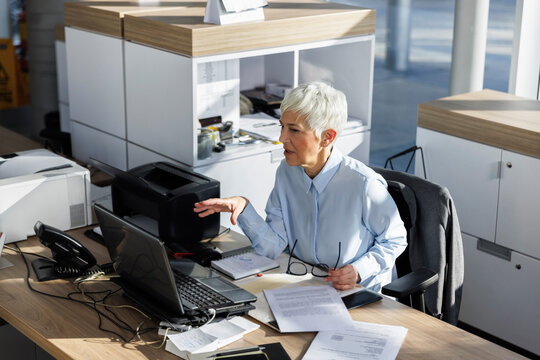 Businesswoman gesturing on video call through laptop at desk in office