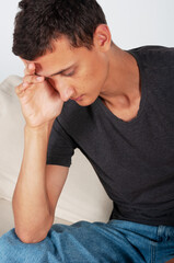 young man bowed his head in thought, headache or problems in life