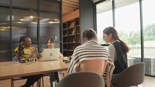 Teachers from diverse collaborate closely, guiding students through complex projects with encouragement and expertise. Students study robotics and technology in a modern science lab at school..