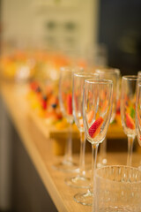 Sparkling glasses on a polished surface, each with fruit, await festive moments