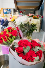 Freshly cut red roses in various arrangements brighten the floral shop, attracting happy customers