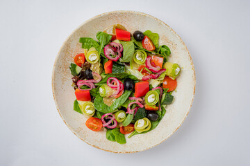 A colorful mix of greens, tomatoes, and olives arranged beautifully, inviting healthy dining