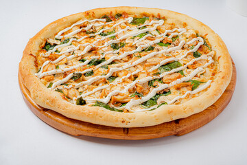Mouthwatering gourmet pizza featuring succulent chicken, vibrant greens, and a rich creamy drizzle