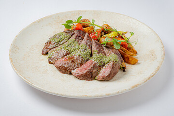 A beautifully presented dish featuring tender grilled steak, vibrant veggies, and aromatic herbs