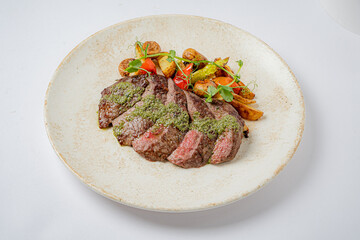Savor the rich flavors of grilled steak garnished with fresh herbs and vibrant seasonal veggies
