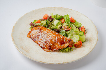 Glazed salmon and a mix of fresh greens and cherry tomatoes create a delightful meal