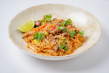 Enjoy a vibrant, spicy fried rice dish garnished with lime and fresh herbs!