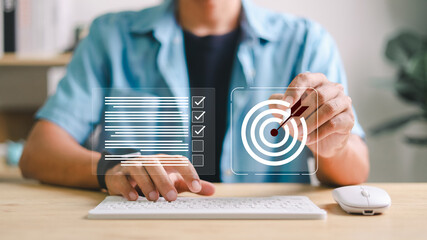 Businessman using virtual interface to set goals and manage checklist tasks on computer. Concept of productivity, planning, digital transformation, and workflow efficiency.