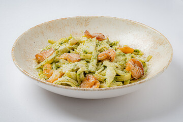 A vibrant pesto pasta dish topped with succulent shrimp, showcasing culinary artistry