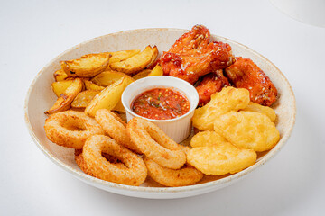 Enjoy crispy chicken wings, golden fries, and fluffy onion rings with delicious dipping sauce