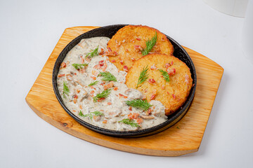 Crispy golden potato cakes with rich sauce, garnished with fresh herbs