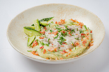 Creamy seafood topped with fresh herbs and veggies, served with cucumber slices