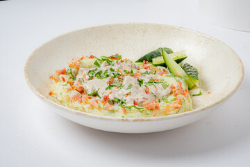 A savory dish with creamy sauce, herbs, and refreshing cucumber slices on the side