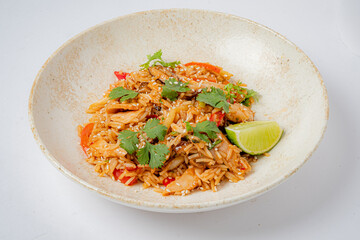 Seasoned chicken fried rice topped with herbs and lime for extra flavor