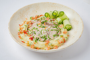 Savory dish with fluffy mashed potatoes, tender meat, and cucumber ribbons with herbs