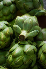 Fototapeta premium Vibrant green artichokes are piled together, highlighting their intricate shapes and textures