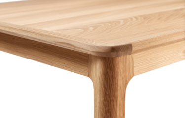 Close-up view of a light-colored wooden table corner