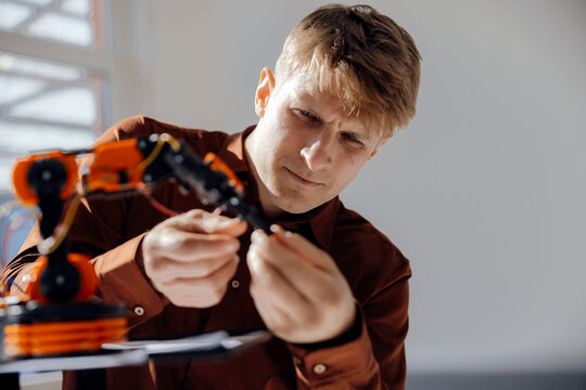 Businessman examining model of robotic arm in office