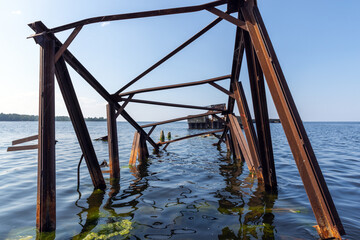 Rusty Metal Bridge Structure Partially Submerged in Tranquil Waters