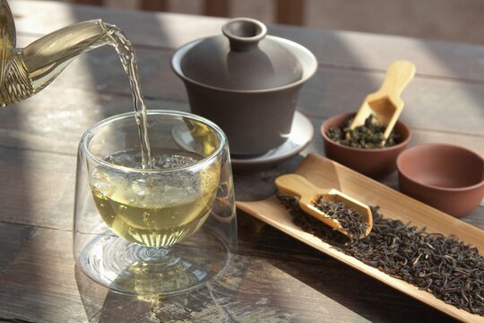 Chinese tea, making tea in a traditional, in a small cups and teapot over dark background
